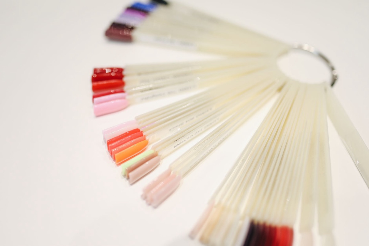 A professional hair color swatch fan showing various hair shades.